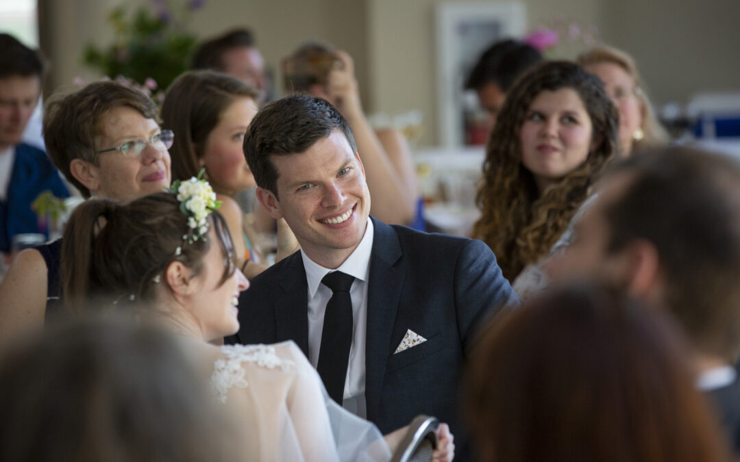 groom smiles at camera during wedding reception