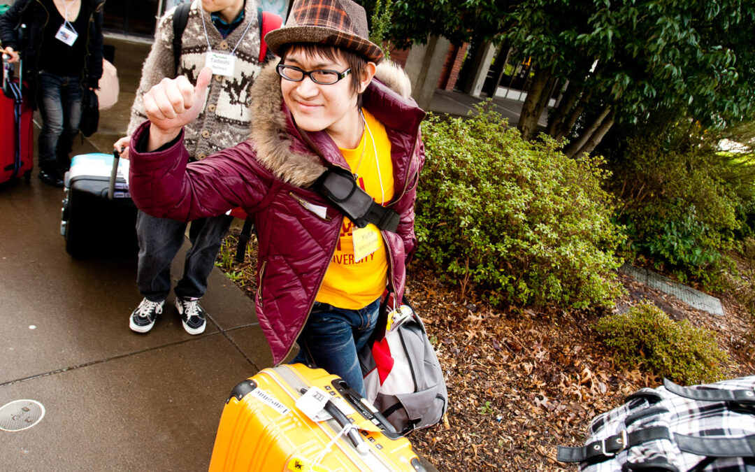 confident looking young man with orange suitcase