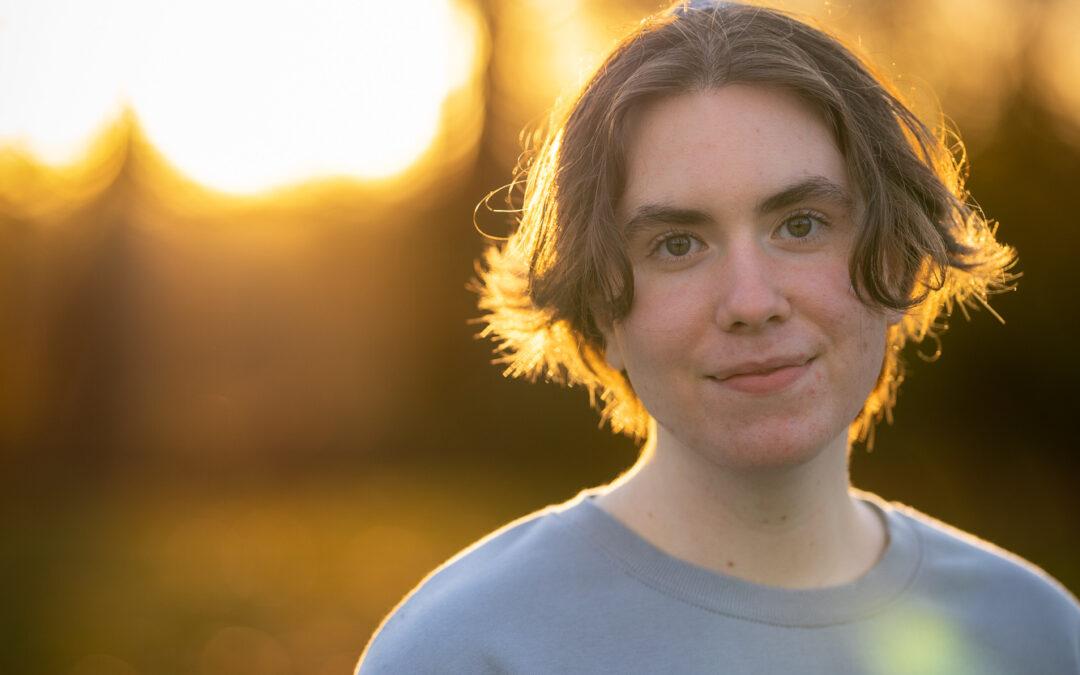 young transgendered male with setting sun in background