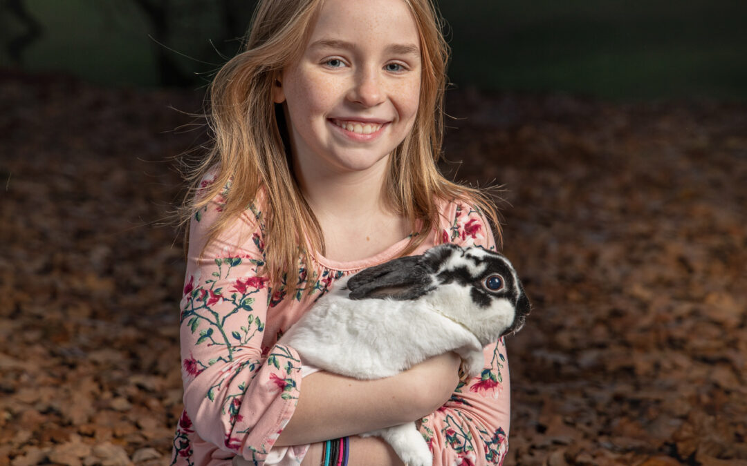 smiling blonde girl holding pet rabbit