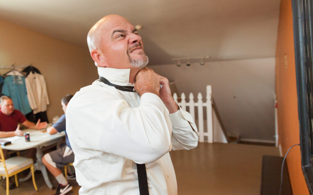 groom struggles with tying bowtie