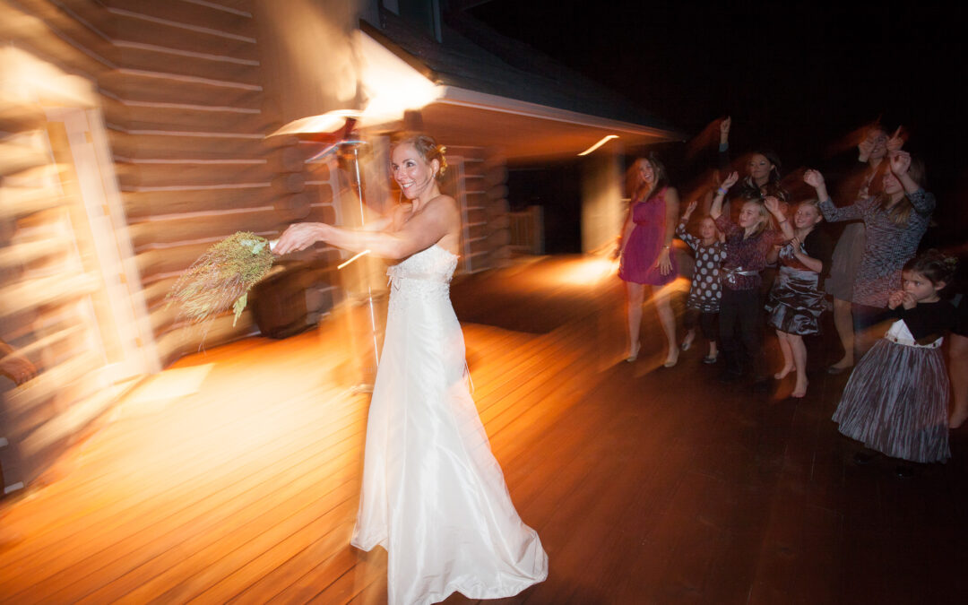 young woman bride throws bouquet to wedding guests