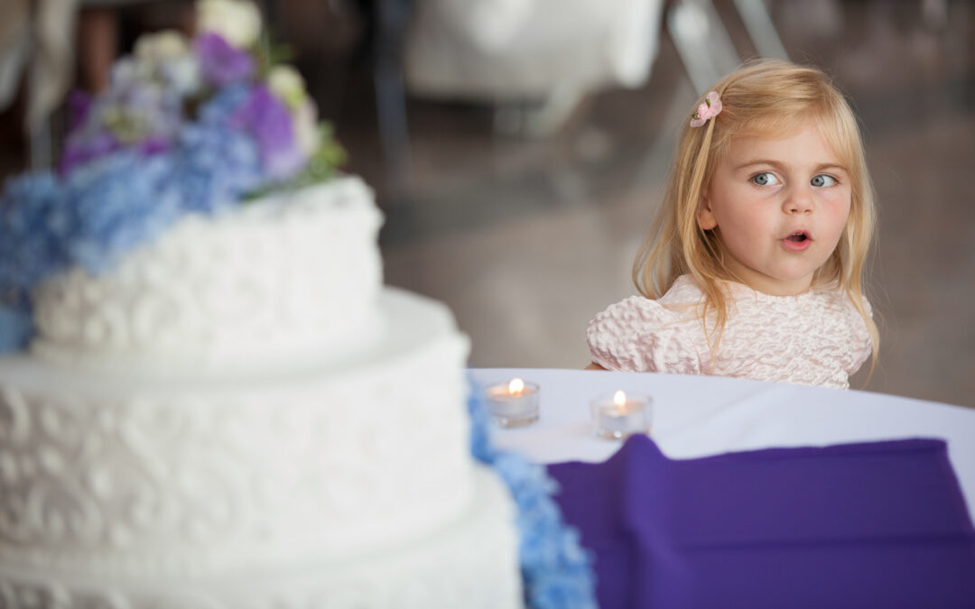 little girl looks excitedly at wedding cake