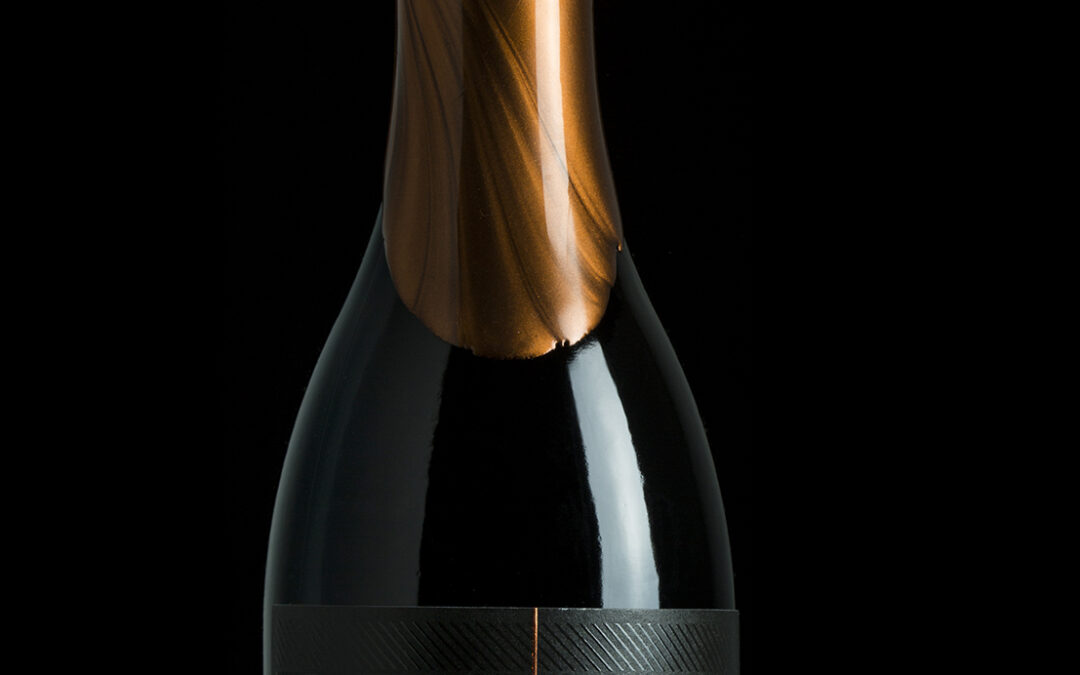 single bottle of red wine against black background