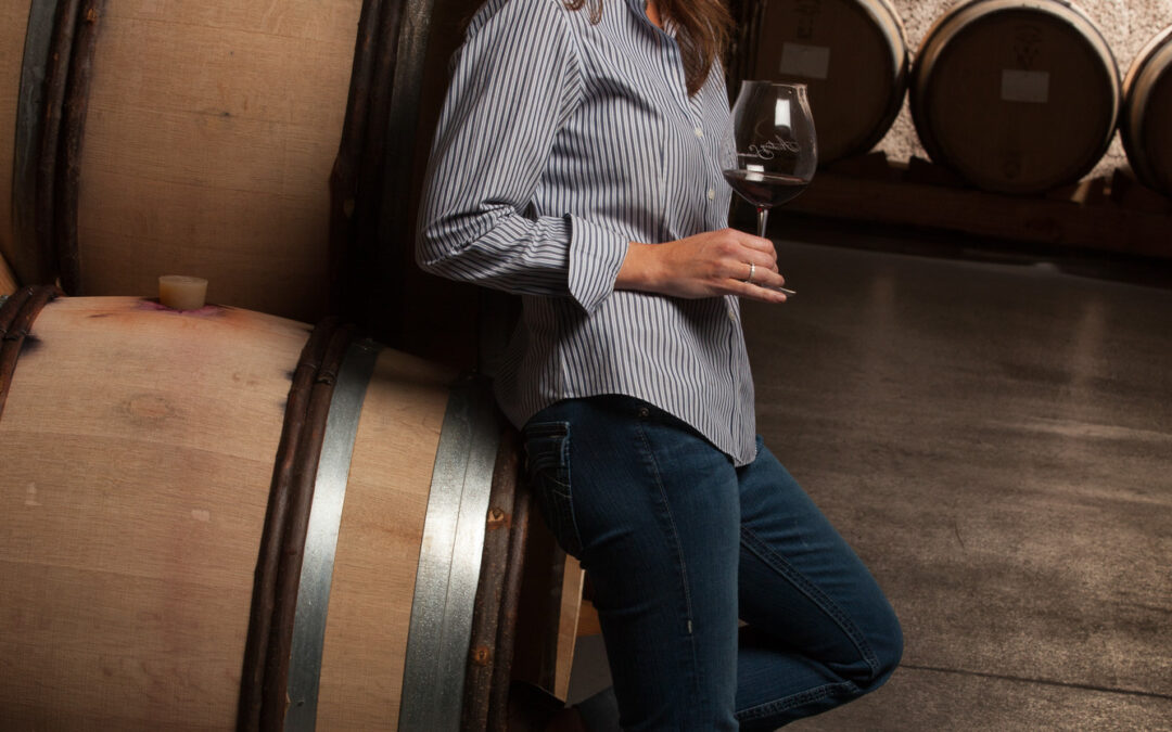 portrait of a woman holding wine glass in cellar