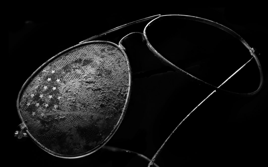 black and white macro close up of dirty and broken glasses with american flag motif